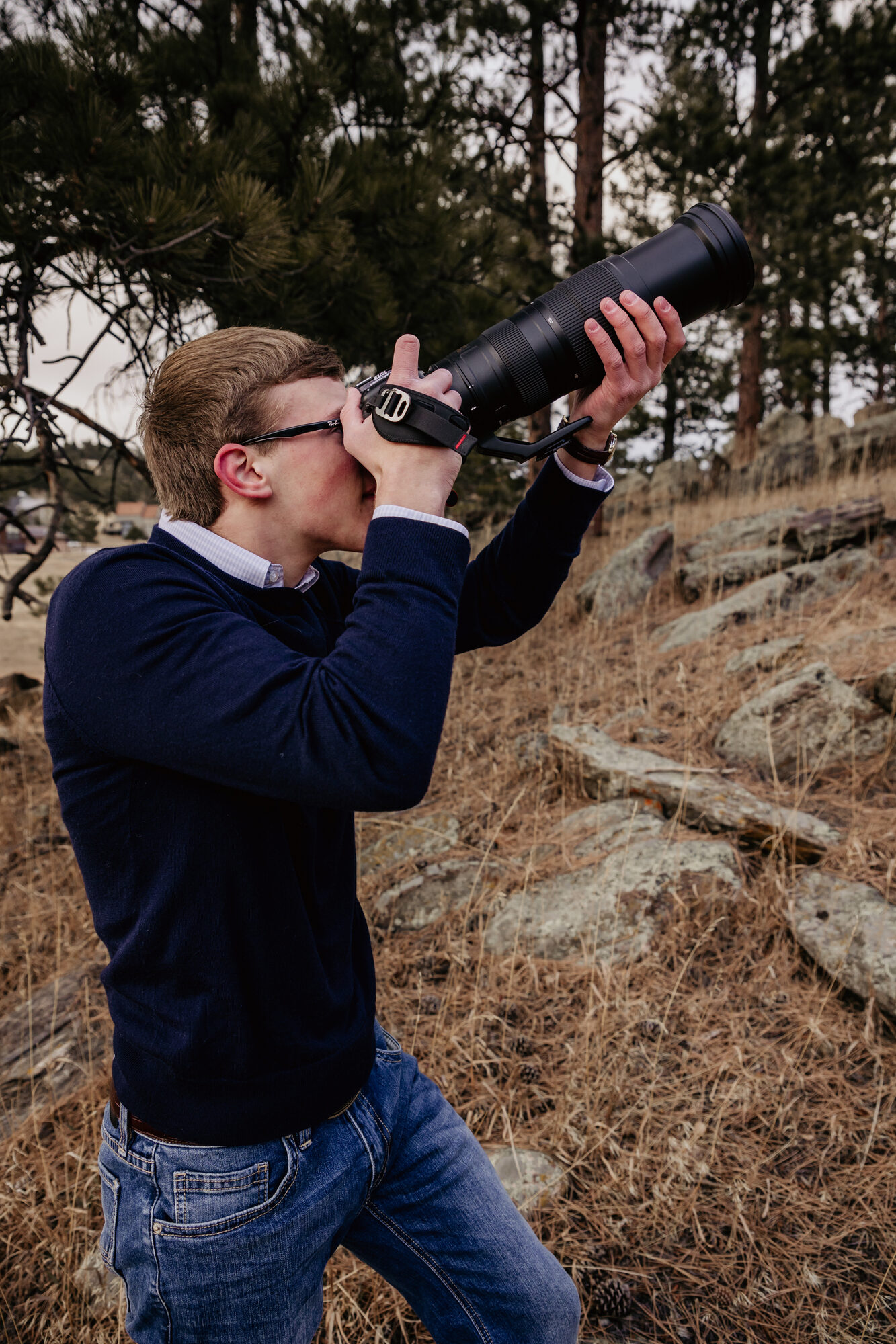 Jacob Citron photographing something in the trees - high school senior photos, 2023